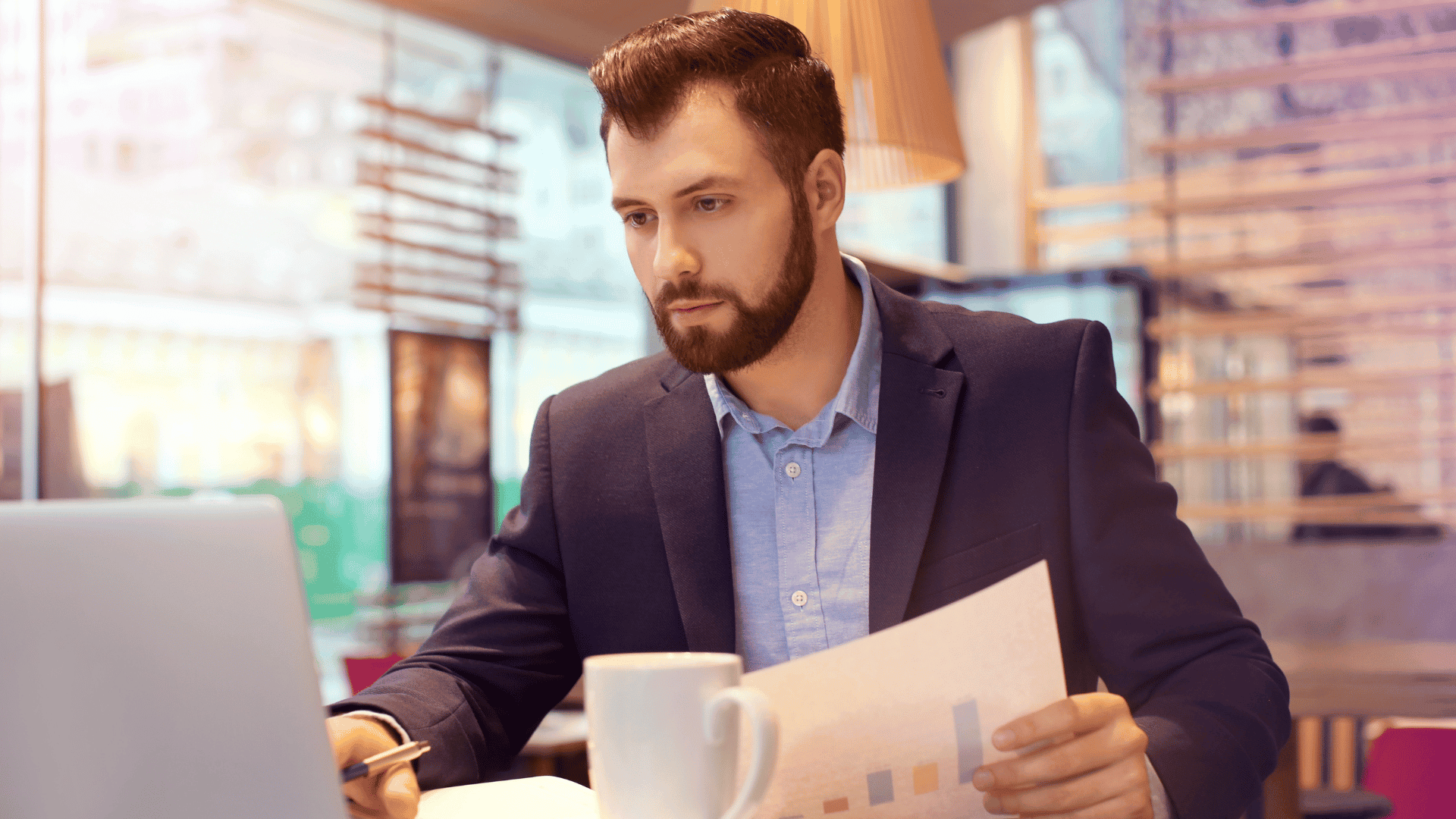 Un hombre mirando un portátil con un diagrama de modelo de negocio en la pantalla